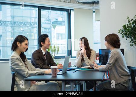 Hommes et femmes souriant et parlant pendant le travail de bureau Banque D'Images