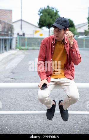 Homme dans la vingtaine souriant au café Banque D'Images