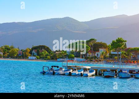 Plage de Mondello à Palerme, Sicile Italie. Scène côtière avec plusieurs bateaux amarrés à un quai, sur fond de verdure luxuriante et de montagnes. Mer Banque D'Images