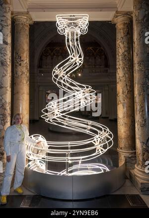 V&A, LONDRES, ROYAUME-UNI. 25 novembre 2024. Le sapin de Noël de 2024 conçu par Anna Lomax (photo), intitulé « All Illumined Up », est installé sous l’atrium de l’entrée principale du musée. « All lit Up » réinvente le traditionnel arbre de Noël comme une colonne haute et tordue qui agit comme une intervention audacieuse et ludique. Crédit : Malcolm Park/Alamy Live News Banque D'Images