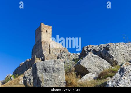 Château d'Atienza. Un grand bâtiment en pierre se trouve sur une colline avec un ciel bleu clair au-dessus. Le bâtiment semble abandonné et les rochers environnants Banque D'Images