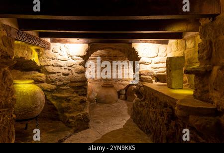Ancien entrepôt de style médiéval. Une ancienne chambre avec un mur de pierre et un grand vase sur le sol. La pièce est faiblement éclairée, ce qui lui donne un mystérieux et EE Banque D'Images