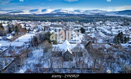 Grantown-on-Spey Écosse ciel bleu hiver toit couvert de neige de l'église Inverallan d'Écosse et regardant vers Church Avenue vers les collines de Cromdale Banque D'Images