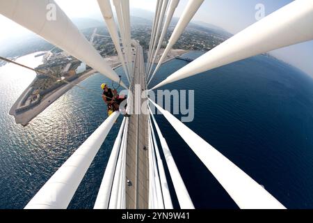 Un homme travaillant à l'entretien du pont suspendu à haubans le plus long du monde près de Patras, en Grèce. (fish-eye) Banque D'Images