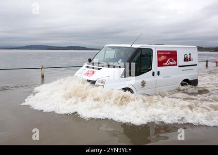 Fourgon conduisant dans une rue inondée à Storth à l'estuaire de la rivière Kent Banque D'Images
