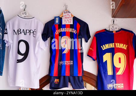 Un maillot du footballeur Robert Lewandowski du FC Barcelone à prix deux fois réduit est accroché dans une boutique de souvenirs à Mijas près de Malaga à côté des maillots de Kylian Banque D'Images