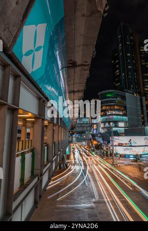 Une vue nocturne du paysage urbain animé de Bangkok, avec des bâtiments illuminés, des rues animées et des feux de circulation colorés Banque D'Images