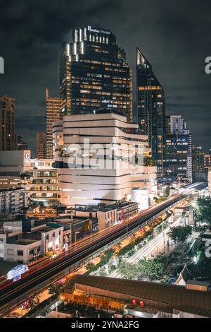 Une vue nocturne du paysage urbain animé de Bangkok, avec des bâtiments illuminés, des rues animées et des feux de circulation colorés Banque D'Images