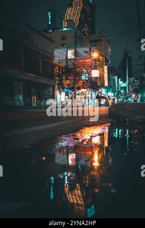 Une vue nocturne du paysage urbain animé de Bangkok, avec des bâtiments illuminés, des rues animées et des feux de circulation colorés Banque D'Images