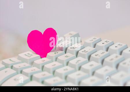 Coeur de papier rose sur clavier d'ordinateur, concept de la saint-valentin Banque D'Images