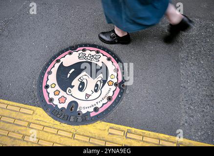 Japon, île Honshu, Kanto, Tokyo, couvercle de trou d'homme manga décoré, Astro Boy, auteur, Osamu Tezuka. Banque D'Images