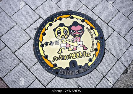 Japon, île de Honshu, Kanto, Tokyo, couvercle de trou d'homme manga décoré, lutteurs sumo. Banque D'Images
