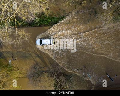 Une voiture traverse les eaux de crue au Billing Aquadrome dans le Northamptonshire. La tempête Bert continuera d'entraîner des perturbations lundi après des pluies torrentielles qui ont provoqué des inondations « dévastatrices » au cours du week-end. Date de la photo : lundi 25 novembre 2024. Banque D'Images
