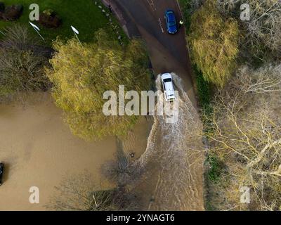 Une voiture traverse les eaux de crue au Billing Aquadrome dans le Northamptonshire. La tempête Bert continuera d'entraîner des perturbations lundi après des pluies torrentielles qui ont provoqué des inondations « dévastatrices » au cours du week-end. Date de la photo : lundi 25 novembre 2024. Banque D'Images