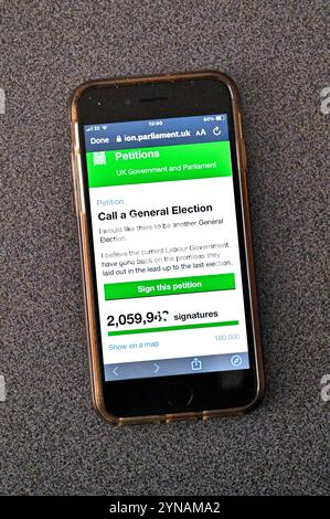 ROYAUME-UNI. 25 novembre 2024. Le site web de pétition du gouvernement affiché sur téléphone portable, affichant une pétition appelant à une élection générale devient viral et atteint 2 millions de signatures juste avant l'heure du déjeuner aujourd'hui. Le Parlement débattra de cette pétition le 6 janvier 2025. Crédit : Craig Brown/Alamy Live News Banque D'Images