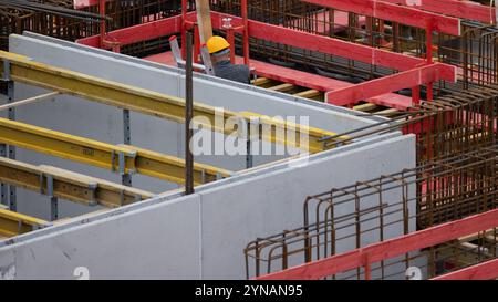 Cologne, Allemagne. 25 novembre 2024. Un ouvrier travaille sur une coquille pour des condominiums dans le district d'Ehrenfeld. Le nombre de permis de construire reste faible. Crédit : Rolf Vennenbernd/dpa/Alamy Live News Banque D'Images