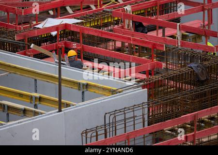 Cologne, Allemagne. 25 novembre 2024. Un ouvrier travaille sur une coquille pour des condominiums dans le district d'Ehrenfeld. Le nombre de permis de construire reste faible. Crédit : Rolf Vennenbernd/dpa/Alamy Live News Banque D'Images