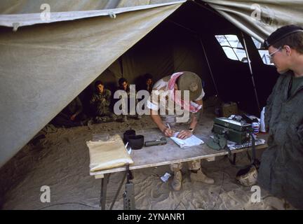 Première Guerre du Golfe : 11 mars 1991 Un soldat britannique du 1st Queen's Own Highlanders garde des prisonniers de guerre irakiens dans une tente de campagne au siège divisionnaire britannique au Koweït. Banque D'Images