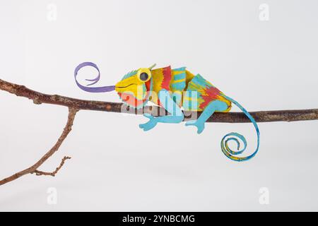 Caméléon coloré à la main à partir de matériaux recyclés tels que le carton de boîte à oeufs vide, assis sur la branche, idée artisanale de bricolage écologique pour l'environnement Banque D'Images