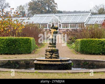 Fontaine à Helmsley Walled Garden vue sur la toile de fond de la serre victorienne. Yorkshire du Nord. ROYAUME-UNI. Banque D'Images