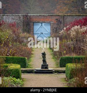 Fontaine dans Helmsley Walled Garden avec des portes en bois bleu comme toile de fond. ROYAUME-UNI Banque D'Images