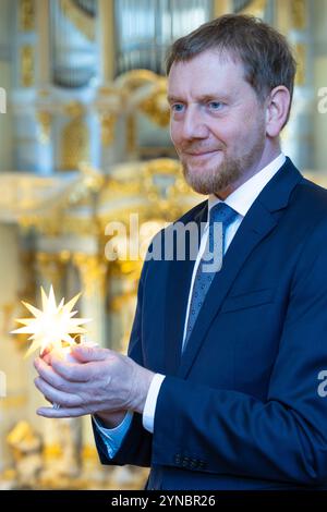 Dresde, Allemagne. 25 novembre 2024. Herrnhuter Sterne GmbH et Stiftung Frauenkirche Dresde présentent conjointement l'édition Herrnhuter 'Frauenkirche Dresden' et remettent la première étoile au ministre-président de l'État libre de Saxe, Michael Kretschmer. Pour marquer 20 ans de coopération entre la Fondation Frauenkirche Dresden et Herrnhuter Sterne GmbH, une édition Frauenkirche Dresden a été créée dans la combinaison de couleurs jaune/blanc. Crédit : Jürgen Lösel/dpa/Alamy Live News Banque D'Images