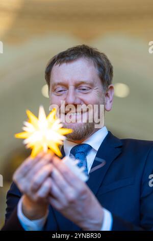 Dresde, Allemagne. 25 novembre 2024. Herrnhuter Sterne GmbH et la Fondation Frauenkirche Dresden présentent conjointement l'édition Herrnhuter 'Frauenkirche Dresden' et remettent la première étoile au ministre-président de l'État libre de Saxe, Michael Kretschmer. Pour marquer 20 ans de coopération entre la Fondation Frauenkirche Dresden et Herrnhuter Sterne GmbH, une édition Frauenkirche Dresden a été créée dans la combinaison de couleurs jaune/blanc. Crédit : Jürgen Lösel/dpa/Alamy Live News Banque D'Images