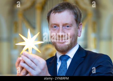 Dresde, Allemagne. 25 novembre 2024. Herrnhuter Sterne GmbH et la Fondation Frauenkirche Dresden présentent conjointement l'édition Herrnhuter 'Frauenkirche Dresden' et remettent la première étoile au ministre-président de l'État libre de Saxe, Michael Kretschmer. Pour marquer 20 ans de coopération entre la Fondation Frauenkirche Dresden et Herrnhuter Sterne GmbH, une édition Frauenkirche Dresden a été créée dans la combinaison de couleurs jaune/blanc. Crédit : Jürgen Lösel/dpa/Alamy Live News Banque D'Images