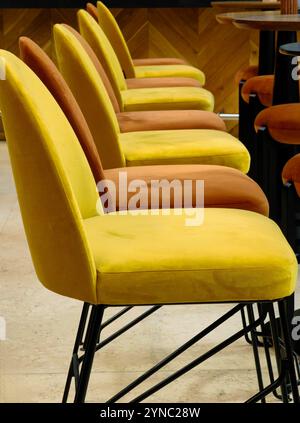 Harmonie colorée : tabourets de bar jaunes et bruns dans un café-restaurant Banque D'Images