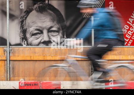 Ein Radfahrer fährt an einem großen Plakat mit dem Porträt des ehemaligen Bundeskanzlers Willy Brandt in der Straße Unter den Linden in Berlin-Mitte vorbei. *** Un cycliste passe devant une grande affiche avec un portrait de l'ancien chancelier allemand Willy Brandt dans la rue Unter den Linden à Berlin Mitte Banque D'Images