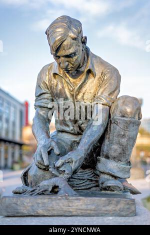 WASHINGTON DC, États-Unis — Une réplique de la statue de Victor Kahill Maine Lobsterman se dresse au quai dans le sud-ouest DC. La sculpture originale en bronze de 1939 représente le pêcheur de l'île Bailey H. Bailey Wilbert dans ses vêtements à l'huile, démontrant la méthode traditionnelle de crochetage des griffes de homard. Un autre moulage de la statue se trouve à Portland, dans le Maine. Banque D'Images