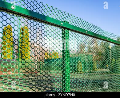 Clôture d'un terrain de sport avec maille en plastique Banque D'Images