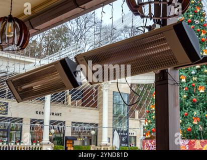 Russie, Kislovodsk - 06 décembre 2023 : lampes chauffantes au-dessus des tables dans un café en plein air Banque D'Images