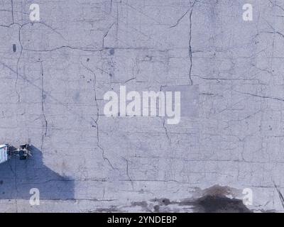 Vue aérienne arrière des fissures dans un parking asphalté. Banque D'Images