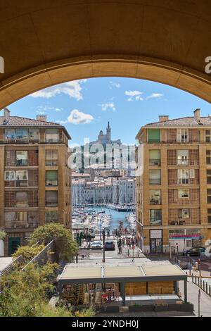 Marseille. France - 25 novembre 2024 : vue imprenable sur le Vieux-Port de Marseille encadré par une arche architecturale moderne, mettant en valeur le mélange d'histo Banque D'Images