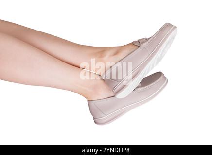 Pieds dans des mocassins en cuir élégants, un slip tendance et confortable sur les chaussures. Design élégant et moderne avec détail chaîne, parfait pour un été détendu ou Banque D'Images