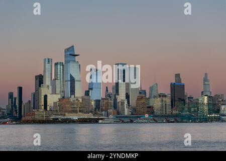 Les superbes gratte-ciel de New York Midtown comprennent de grands bâtiments modernes reflétant les couleurs du crépuscule au coucher du soleil. Le front de mer ajoute un élément serein. Banque D'Images