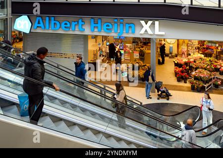 Façade du supermarché Albert Heijn XL à l'intérieur du centre commercial de Diemen, près d'Amsterdam. Acheteurs sur escaliers roulants, dont un portant un sac plastique bleu de la marque Banque D'Images