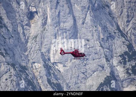 Hélicoptère Airbus H135 utilisé comme hélicoptère de sauvetage pour le médecin urgentiste et le service de sauvetage en montagne, volant devant les parois rocheuses de th Banque D'Images