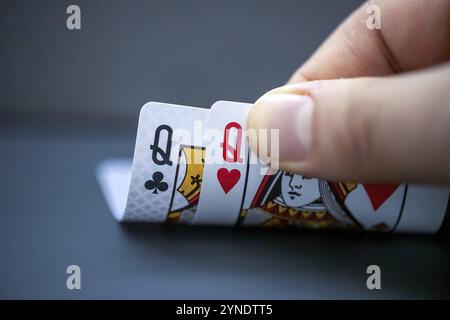 Calgary, Alberta, Canada. 18 décembre 2023. Une personne regardant à la main de départ couple de cartes de reines pendant un jeu de poker. Concept : les monstres grandes paires Banque D'Images