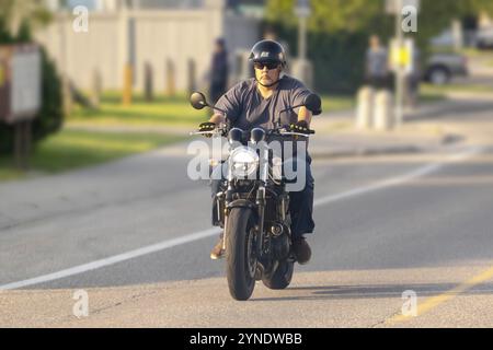 Calgary, Alberta, Canada. 12 juillet 2024. Un motocycliste casqué naviguant sur un itinéraire de jour pendant les conditions estivales Banque D'Images