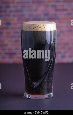 Un sombre Guinness Irish Stout sec verre de bière provenant de la brasserie de dublin vue verticale Banque D'Images