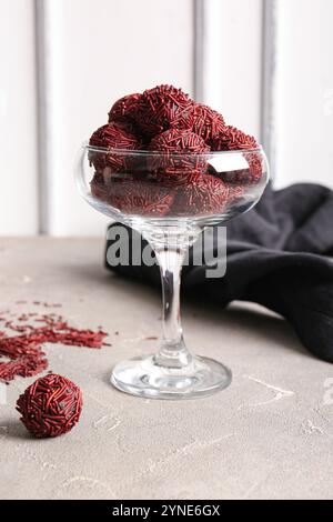 Verre avec des truffes au chocolat sur table grise Banque D'Images