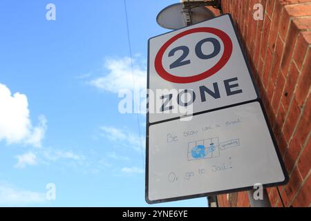 20 mph zone de restriction de vitesse signe dans la route résidentielle Salisbury Wiltshire UK limite de vitesse de sécurité routière être lent comme un escargot ou aller en prison Banque D'Images