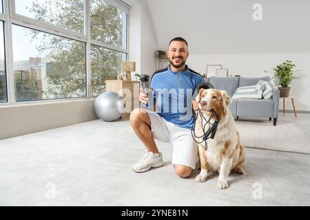 Jeune homme et berger australien avec équipement de sport à la maison Banque D'Images