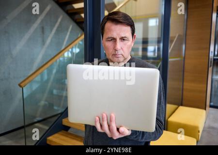 17 novembre 2024 : un homme réfléchi avec un ordinateur portable à la main. Image symbolique pour l'intimidation et le discours de haine au travail ou dans l'environnement numérique *** Ein nachdenklicher Mann mit einem Laptop in der Hand. Symbolbild für Mobbing und Hatespeech am Arbeitsplatz oder im digitalen Umfeld Banque D'Images