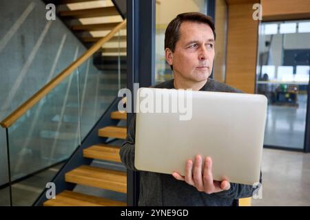 17 novembre 2024 : un homme réfléchi avec un ordinateur portable à la main. Image symbolique pour l'intimidation et le discours de haine au travail ou dans l'environnement numérique *** Ein nachdenklicher Mann mit einem Laptop in der Hand. Symbolbild für Mobbing und Hatespeech am Arbeitsplatz oder im digitalen Umfeld Banque D'Images