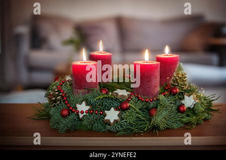 Quatrième Avent, couronne verte avec des boules de Noël, biscuits étoile à la cannelle et bougies rouges, quatre sont allumés, sur une table dans le salon, espace de copie, se Banque D'Images