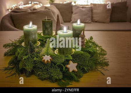 Troisième avènement, couronne avec trois bougies vertes allumées et décoration de Noël sur une table en bois dans le salon, espace copie, foyer sélectionné, dép étroit Banque D'Images