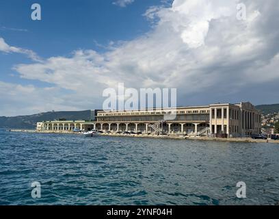 Trieste, Italie - 27 juin 2024 : embarcadère de croisière et bâtiment du terminal de passagers sous un paysage nuageux bleu Banque D'Images